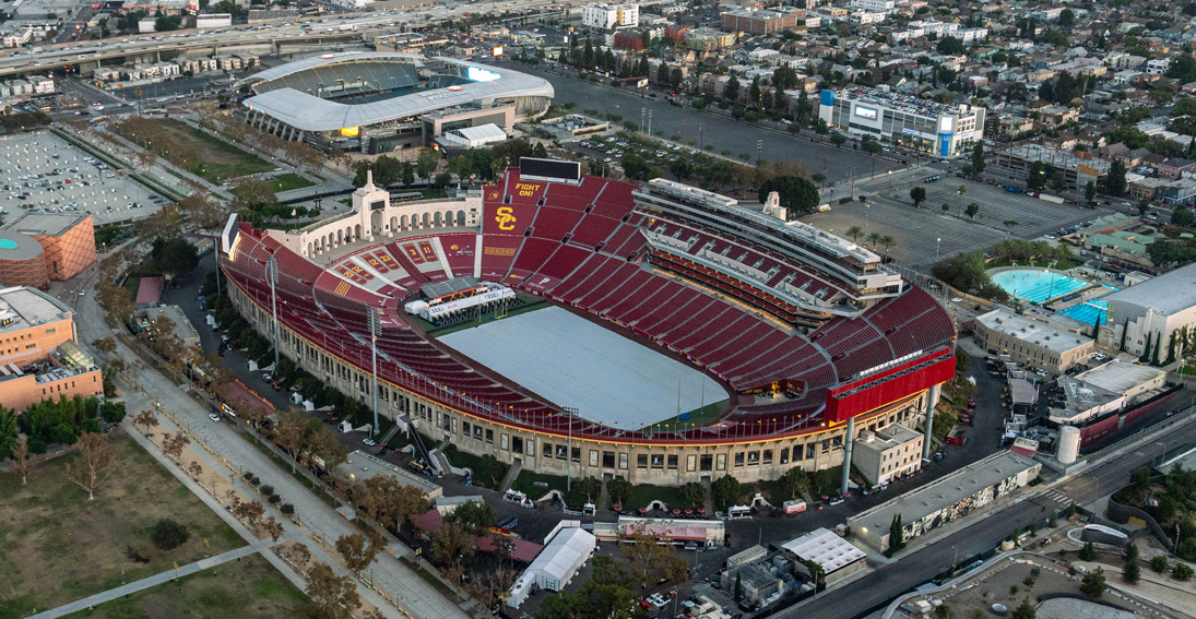 Capture stunning views of USC Coliseum during a helicopter flight over the vibrant city of Los Angeles.