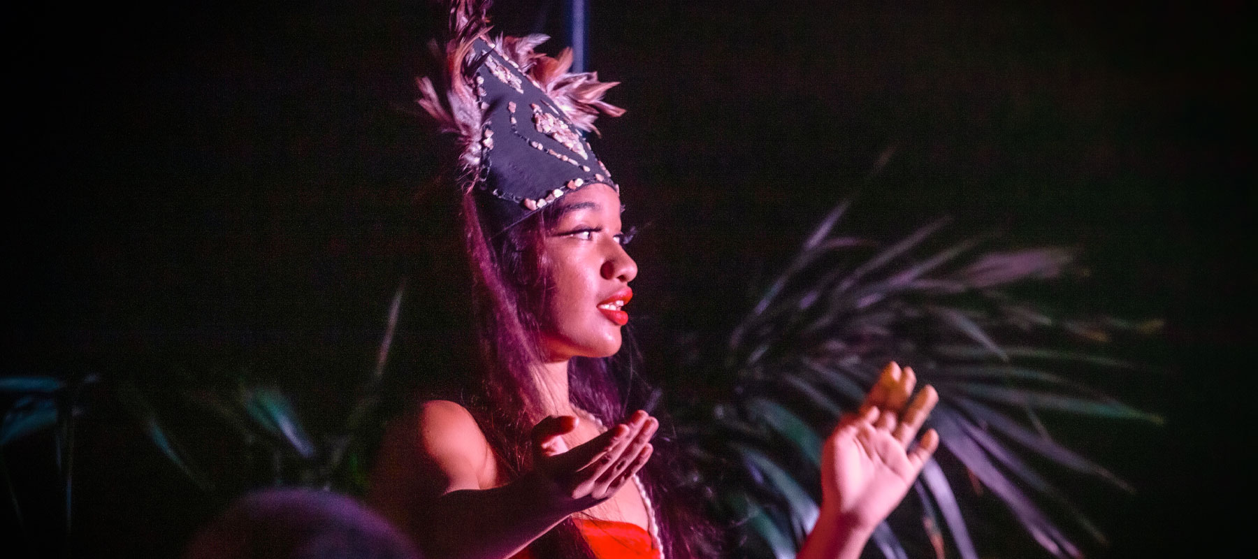 Polynesian dancer wearing a traditional headdress at the Maui Luau Experience