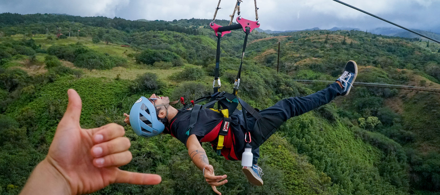 Group of guests gearing up on zipline platform with Maui ocean views in the background