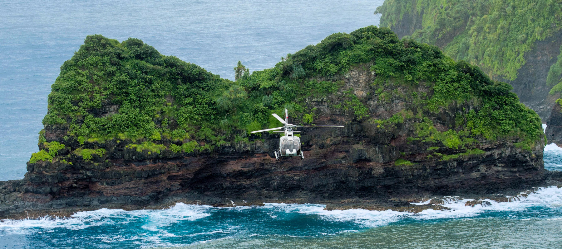 Helicopter flying over Jurassic Rock (Keōpuka Rock) on Maui