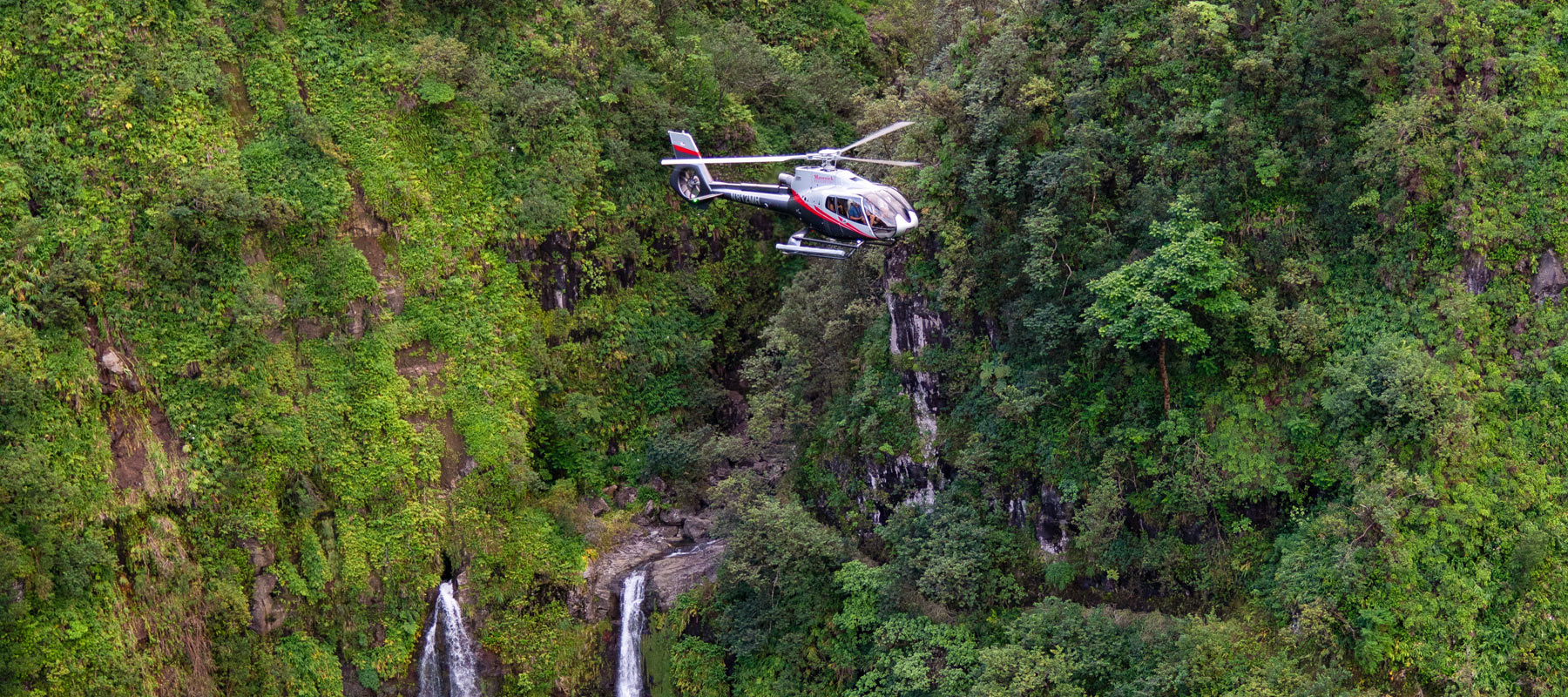 Helicopter flying near the waterfalls of Molokai, Hawaii