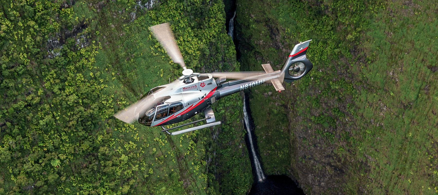 Flying beside a waterfall in the mountains of Molokai