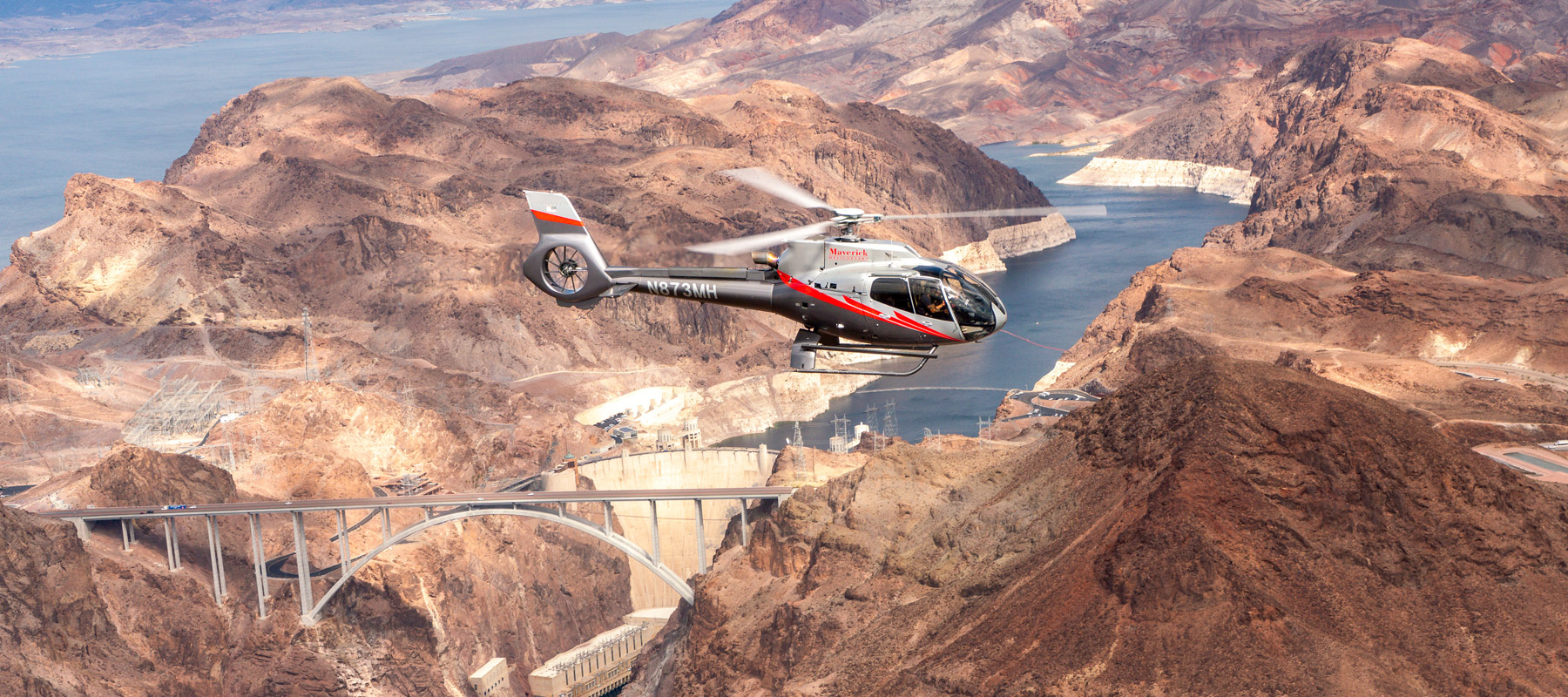 Helicopter flying above the rugged red rock formations of the Grand Canyon