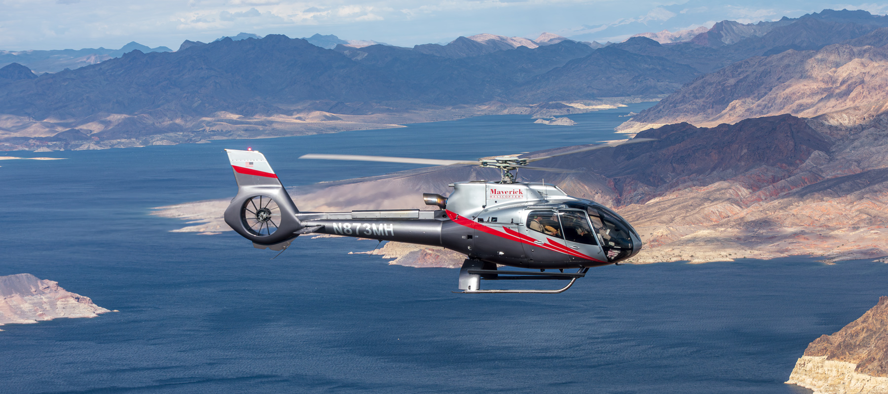 Maverick helicopter flying over the desert landscape near Grand Canyon West