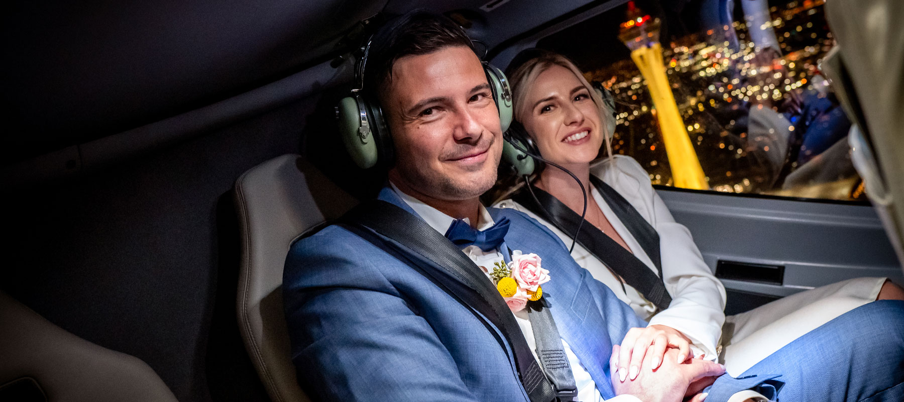 A couple enjoying neon city views from inside the helicopter during their Las Vegas wedding flight