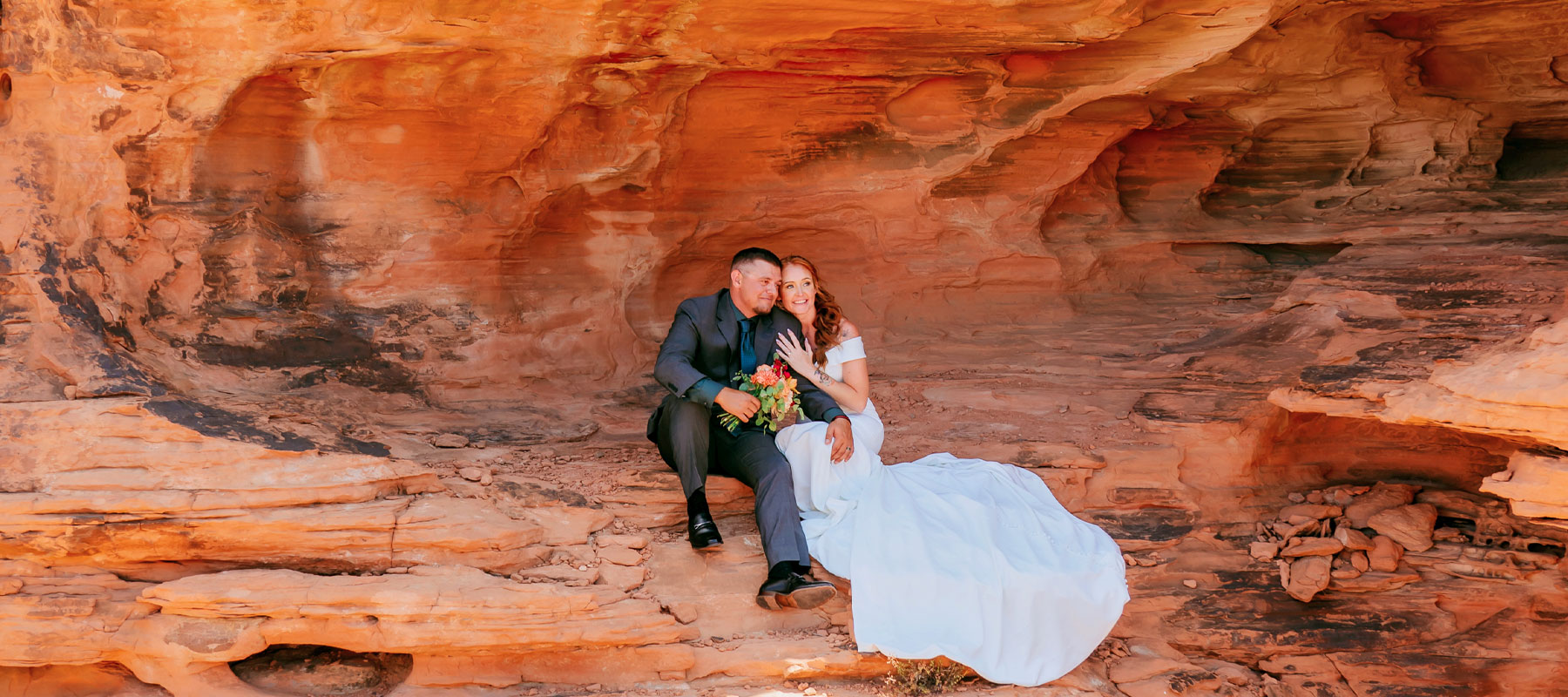 Wedding couple framed by a natural red rock arch at Valley of Fire